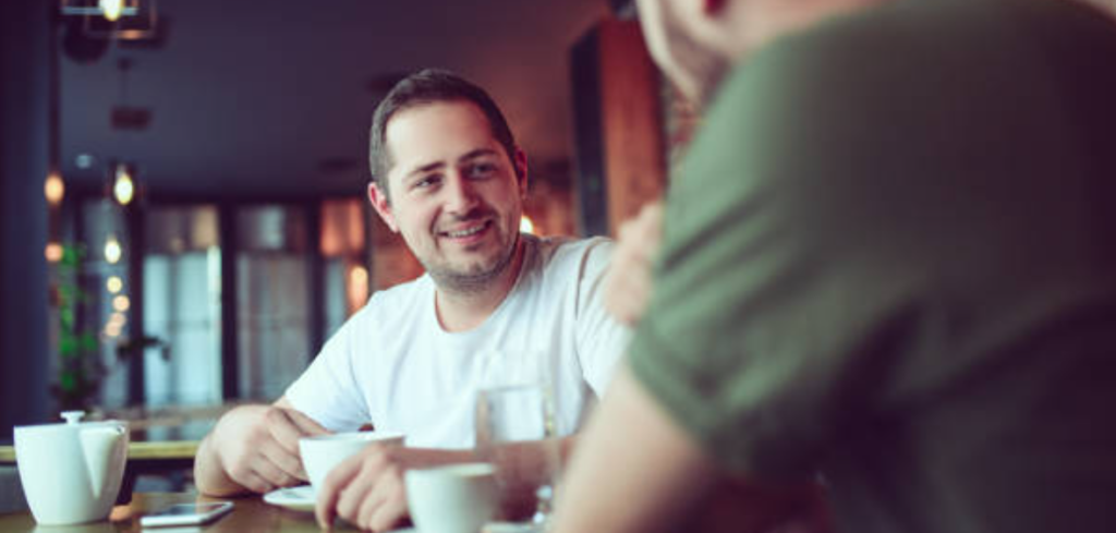 Image of 2 men talking, over coffee